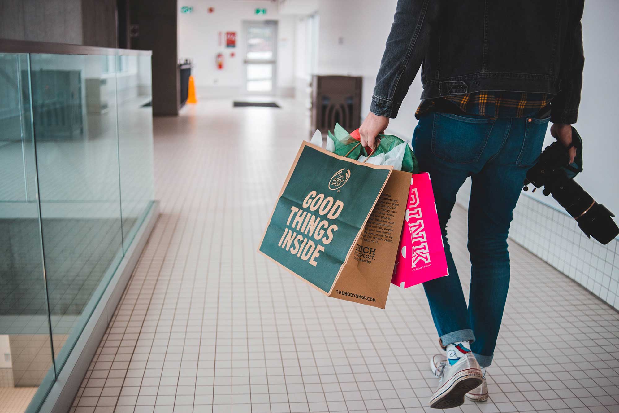 person in mall carrying shopping bags