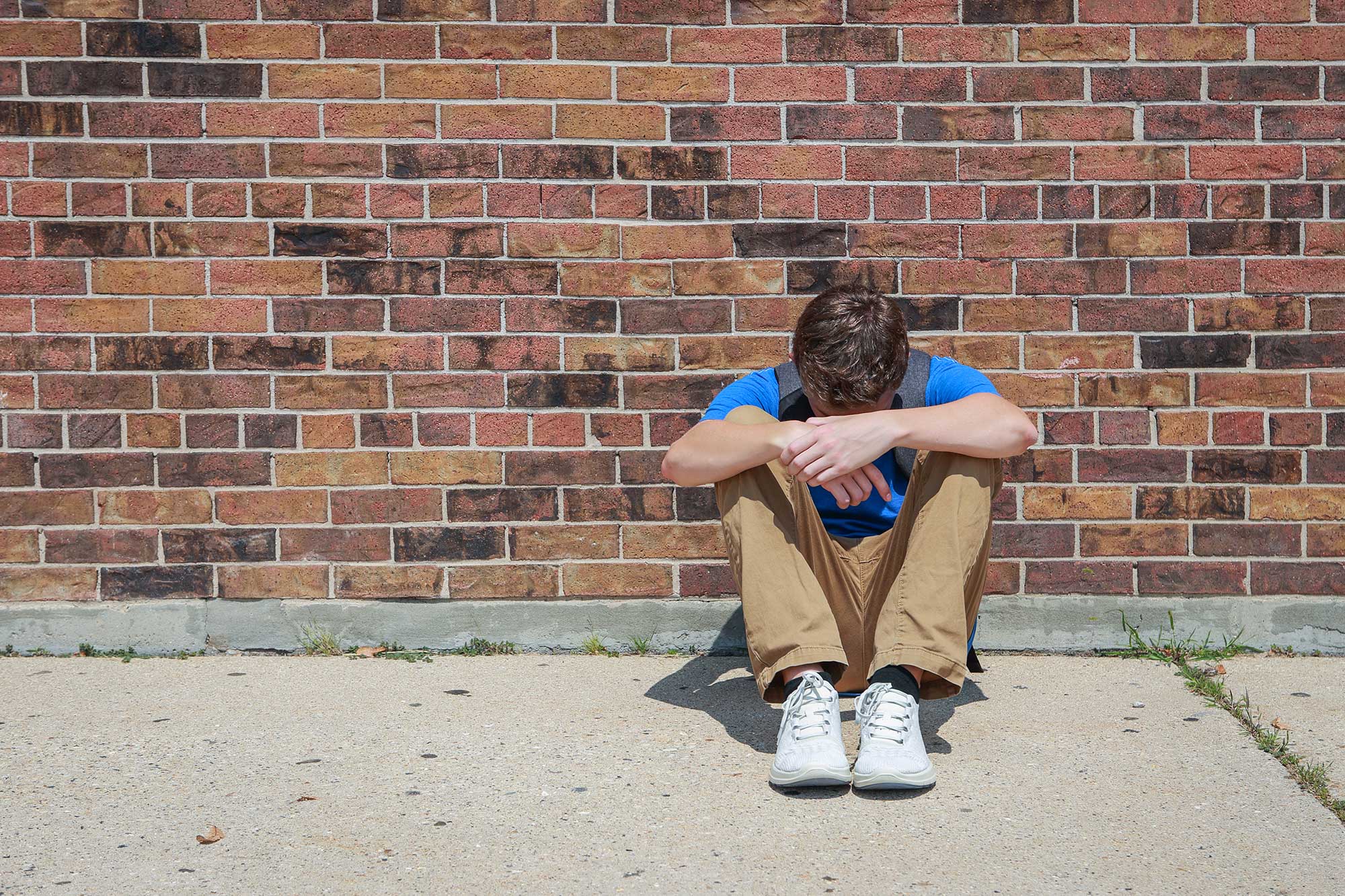 person-slumped-against-wall