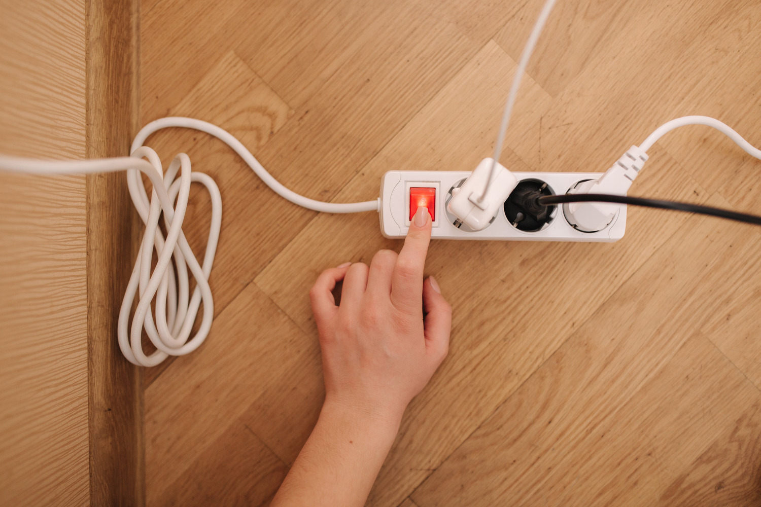 hand turning off power strip