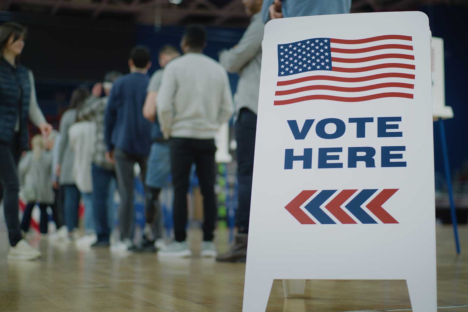 vote here sign with line of voters