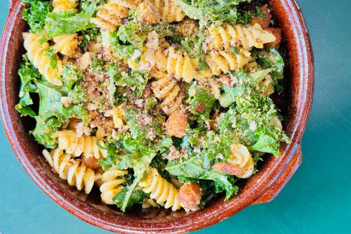 A summer pasta salad with caesar dressing, veggies, and nutritional yeast