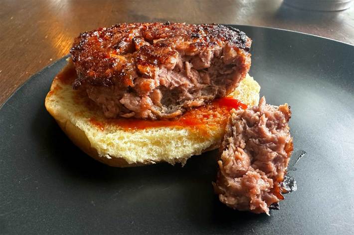 cooked beyond burger with bite on bun