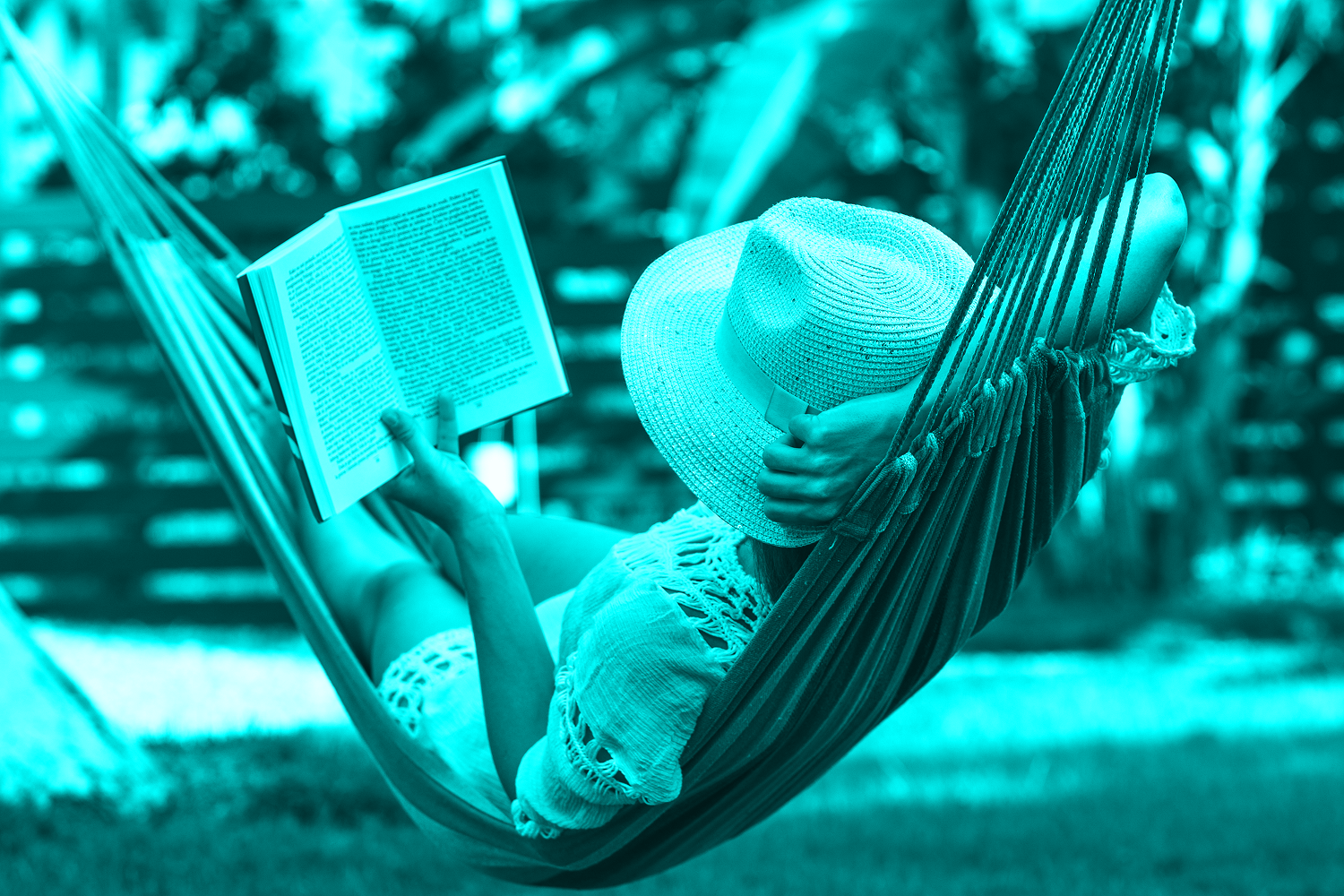 person in hat reading in hammock