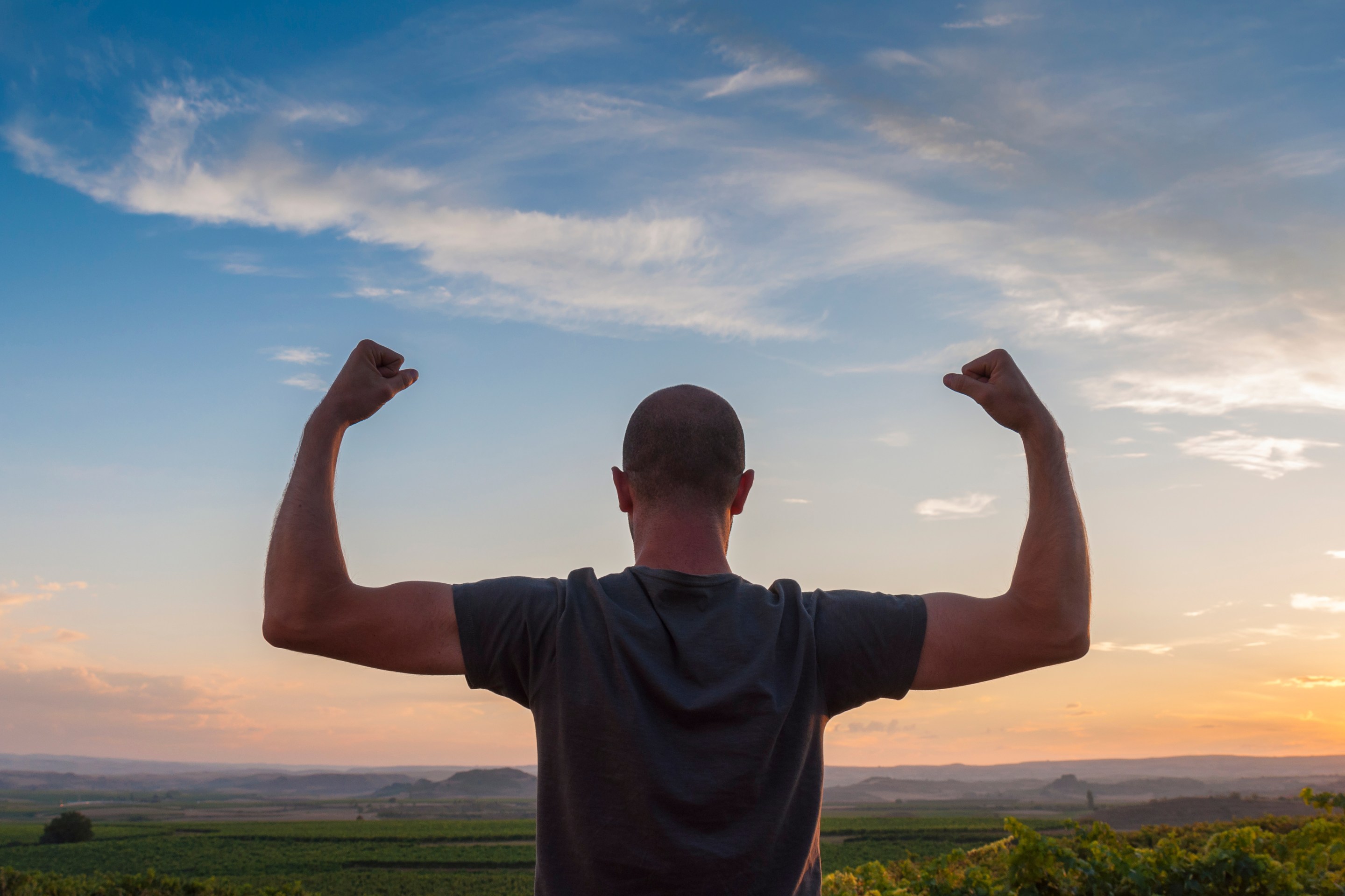 man flexing arms outside