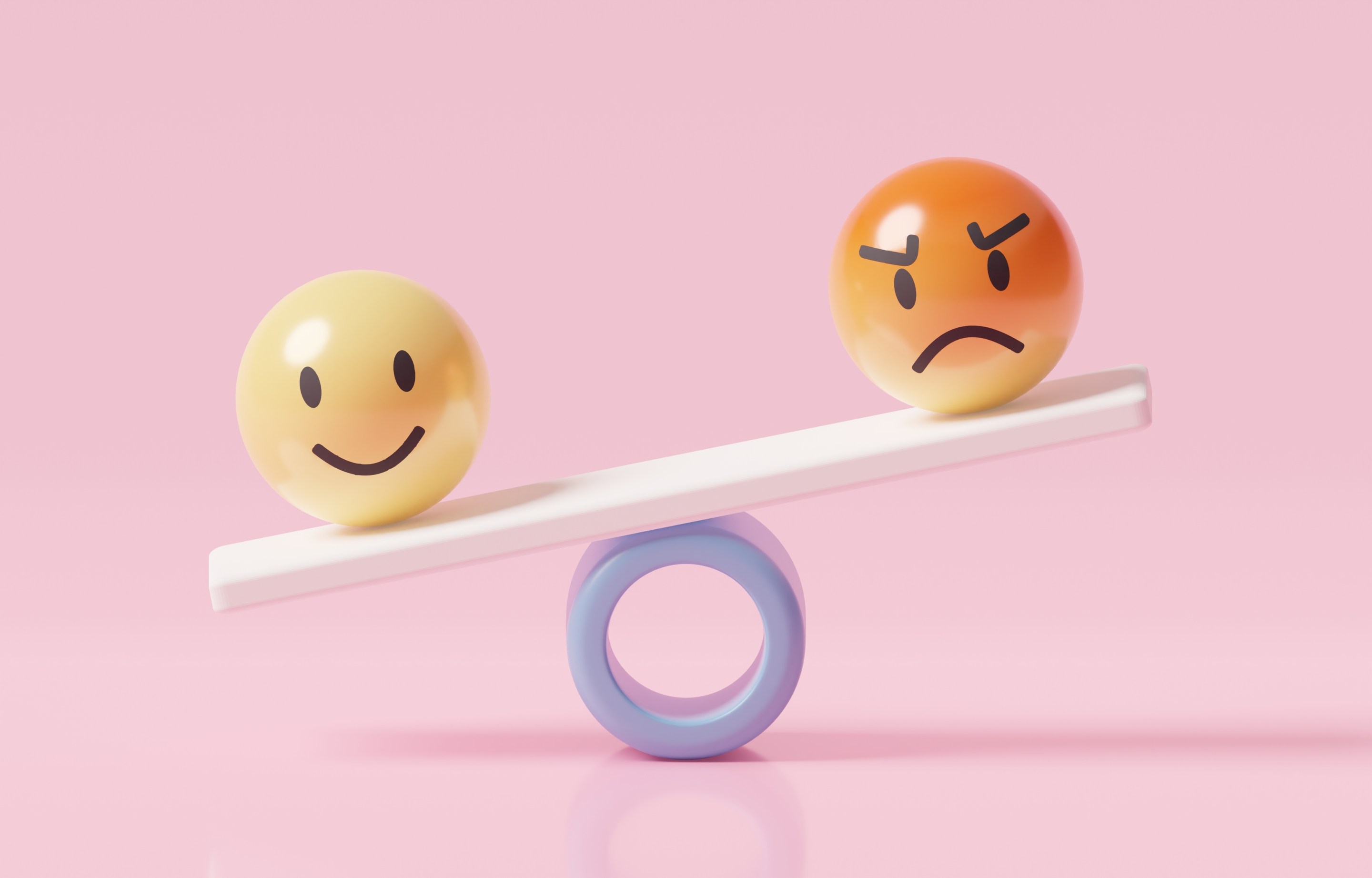 One smiley face, one angry face teetering on a seesaw