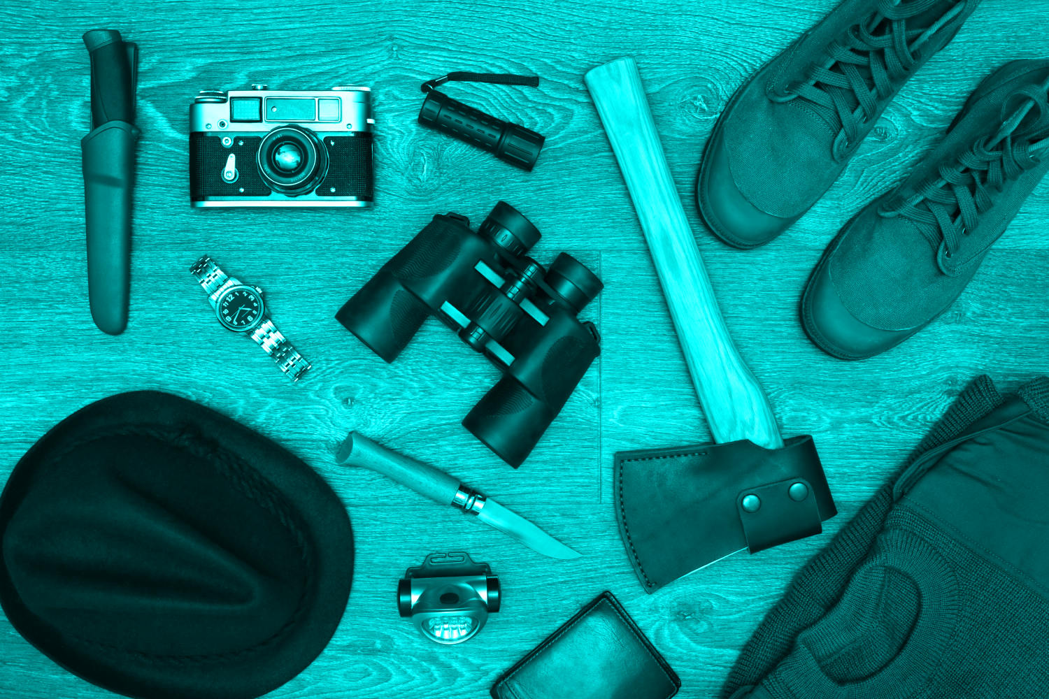 top down image of camera binoculars ax boots and other items