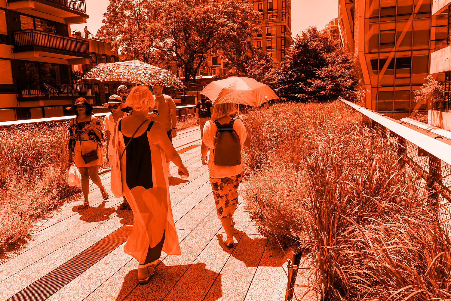 Umbrellas protect tourists from the sun in the High Line Park in New York